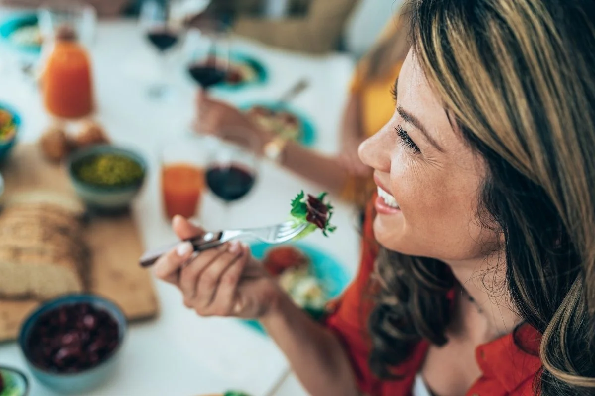 Woman enjoying lunch while earning passive income on her phone, representing financial freedom and flexibility.