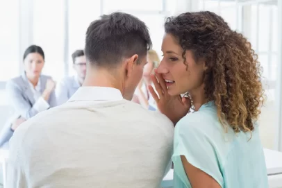 Woman whispering a financial secret to a colleague during a meeting, symbolizing insider investing tips and hidden wealth strategies – concept for “7 Investing Secrets You Need to Know.”