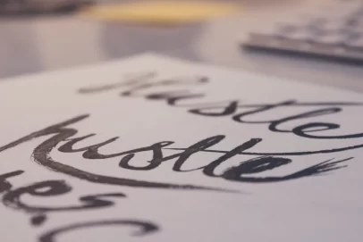 Close-up of the word “hustle” written in bold brush lettering on paper, symbolizing motivation and ambition — perfect for an article titled Do You Know How to Create a Passive Side Hustle.