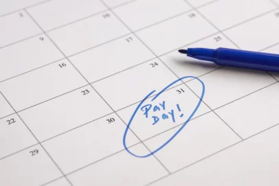 Close-up of a calendar with “Pay Day!” written and circled in blue ink, symbolizing budgeting, financial planning, and breaking free from living paycheck to paycheck — perfect for illustrating How to Escape Paycheck-to-Paycheck Living for Good.