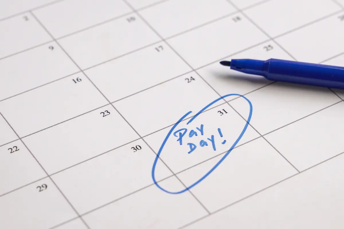 Close-up of a calendar with “Pay Day!” written and circled in blue ink, symbolizing budgeting, financial planning, and breaking free from living paycheck to paycheck — perfect for illustrating How to Escape Paycheck-to-Paycheck Living for Good.