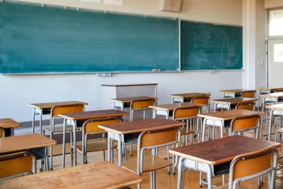 Empty classroom with wooden desks and a large chalkboard, symbolizing the timeless importance of financial education and the 10 important money lessons everyone should learn.