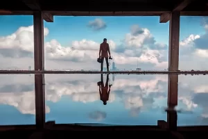 A person standing alone in an open structure overlooking a city skyline, reflecting on decisions that make you rich and long-term success.
