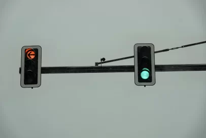 Two traffic lights showing a green light and a left turn arrow, symbolizing the rules self-made millionaires follow when making financial decisions.